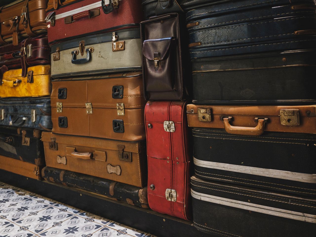 digital A collection of stacked vintage suitcases showcasing classic styles in an indoor setting.