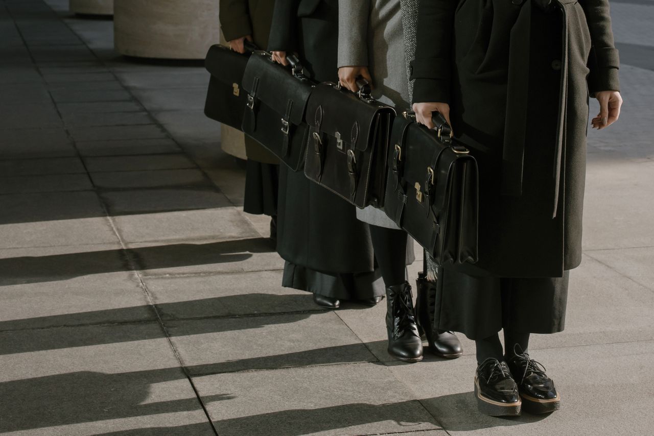 creative A group of business professionals carrying leather briefcases outdoors